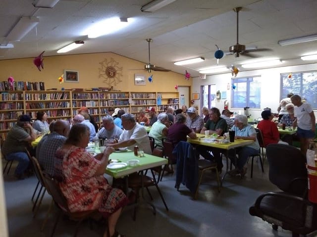 Residents at a First Tuesday potluck dinner in the clubhouse